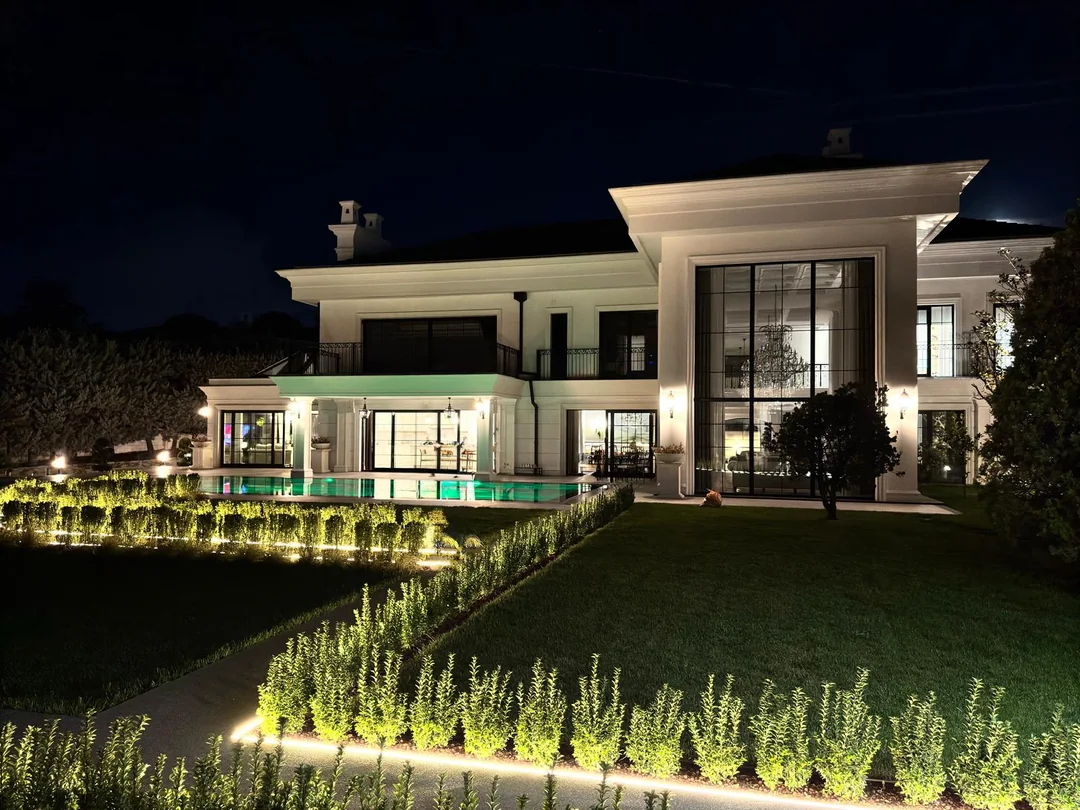Alkent 2000 Villa'nın aydınlatılmış dış cephesi, havuzu ve bahçesinin gece görünüşü